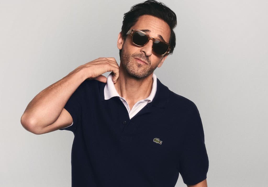 Campaign portrait in a navy polo and amber sunglasses